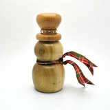 A snowman-shaped wooden ornament or decorative figurine made from light natural wood, featuring a small silver rhinestone band near the top and a red, green, and gold plaid ribbon tied around the middle, set against a plain white background.