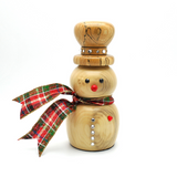 A wooden snowman figurine with a natural light wood finish, featuring a red plaid scarf, a red nose, and rhinestone accents, set against a plain white background.