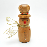 A wooden snowman figurine with a natural light brown finish, featuring a red nose, silver and red buttons, a gold glittery scarf, and a gold glittery hat trim with small decorative beads.